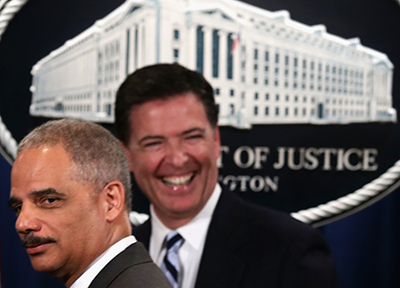FBI Director James B. Comey, pictured right with outgoing Attorney General Eric Holder in June, says FBI efforts to fight crime are being thwarted by moves to protect user privacy. (Alex Wong/Getty Images/AFP)