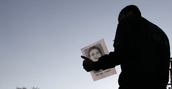 صورة صفحة العنوان: صحفية تحمل صورة للصحفية الإذاعية النيبالية أوما سينغ، التي قُتلت عام 2009. (رويترز/ شروتي شريسثا)