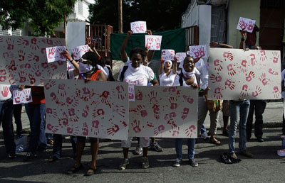Activists demonstrate against human rights abuses committed by Haiti's former dictator Jean-Claude 'Baby Doc' Duvalier outside the St. Louis de Gonzague school chapel, where his funeral is held, in Port-au-Prince on October 11. (Reuters/Marc Lee Steed)