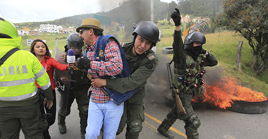 مراسل يحاول إجراء لقاء مع متظاهر أثناء نقله من قبل الشرطة خلال صدامات وقعت بالقرب من بوغوتا عام 2013. لقد تقلص العنف الموجه ضد الصحفيين في كولومبيا، وتقلص معه عدد وفيات الصحفيين. (رويترز/ خوسيه ميغيل غوميز)