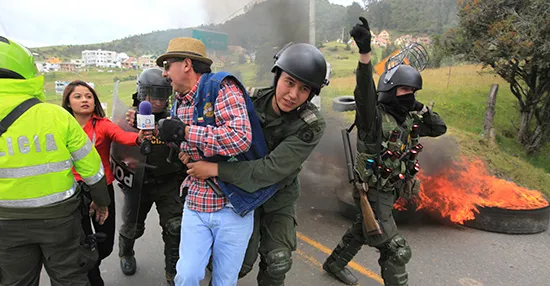 Репортёр в Боготе в 2013 году пытается взять интервью у демонстранта, которого уводят полицейские. Уровень насилия в отношении журналистов в Колумбии несколько снизился, а вместе с ним сократилась и численность случаев гибели журналистов. (Рейтер/Хосе Мигель Гомес)