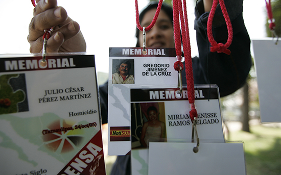 سيدة تحمل بطاقات هويات إعلامية عليها أسماء الصحفيين الذين قُتلوا في المكسيك. (رويترز/أليخاندرو أكوستا)