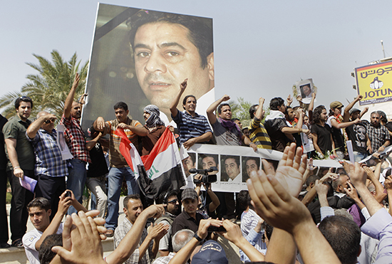 متظاهرون يحتجون على مقتل الصحفي العراقي هادي المهدي، والذي لقي حتفه من جراء إطلاق رصاص. ولم يُعاقب أي شخص على هذه الجريمة. (وكالة أسوشيتد برس/كريم كاظم)