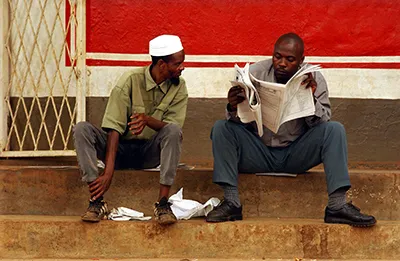 Deux hommes lisent un journal à Kigali. L'accréditation est volontaire pour les journalistes rwandais mais beaucoup disent qu'il est difficile de travailler sans carte de presse. (AFP/Marco Longari)