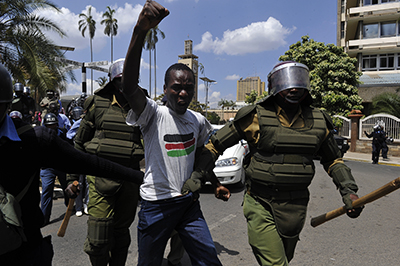 Police arrest one of the protesters who gathered in Nairobi on December 18 to oppose the security bill. (AFP/Simon Maina)