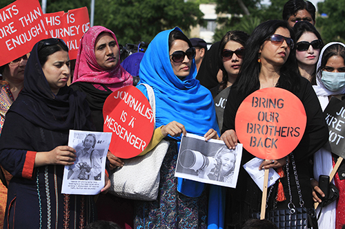 During a demonstration in Pakistan, journalists hold photos of Anja Niedringhaus, an AP photographer who was killed in Afghanistan in April. (Reuters/Faisal Mahmood)