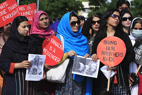 Lors d'une manifestation au Pakistan, les journalistes tiennent des photos d'Anja Niedringhaus, une photographe de l'agence américaine Associated Press (AP) qui a été tuée en Afghanistan en avril. (Reuters/Faisal Mahmood)