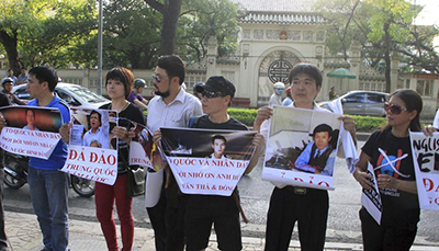 Protesters in Hanoi hold up pictures of jailed bloggers and activists in May 2014. Hopes that authorities would end the repression of bloggers have faded with the arrest of three more writers. (Reuters/Nguyen Huu Vinh)