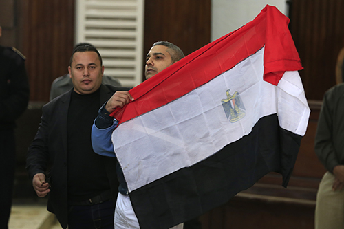 Mohamed Fahmy holds an Egyptian flag on February 12 after a court ruled he and Al-Jazeera colleague Baher Mohamed could be released on bail. (AP/Hassan Ammar)