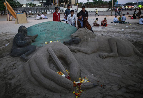 A sand sculpture in Mumbai for victims of the Charlie Hebdo attack. An editor arrested after complaints over her decision to publish an image of the French magazine's cover has gone into hiding in India. (Reuters/Danish Siddiqui)