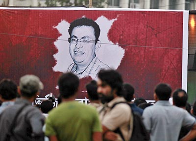 Protesters in Dhaka gather around the portrait of Avijit Roy, a blogger who was killed on Thursday. (AP/A.M. Ahad)