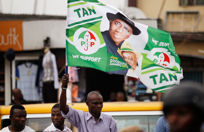 A man holds a flag in support of Nigerian President Goodluck Jonathan at a campaign rally in Ikeja district in Lagos February 3. (Reuters/Akintunde Akinleye)