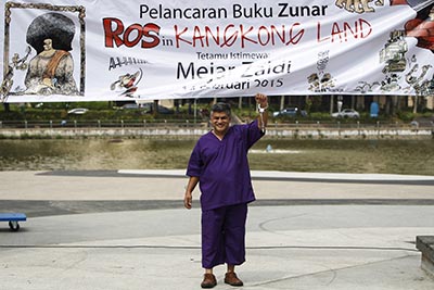 Malaysian cartoonist Zunar poses in plastic handcuffs prior to the launch of his new book of political cartoons. (AP/Joshua Paul)