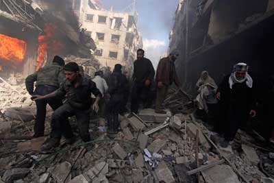 People walk on rubble after what activists said were airstrikes and shelling by forces loyal to Syria's President Bashar al-Assad in the Douma neighborhood of Damascus, February 9, 2015. (Reuters/Mohammed Badra)