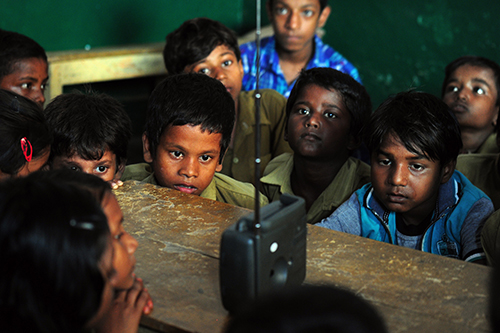 Schoolchildren in Allahabad listen to Modi giving a speech on radio in September. The prime minister uses social media and other methods to spread his message instead of relying on the press, journalists say. (AFP/Sanjay Kanojia)