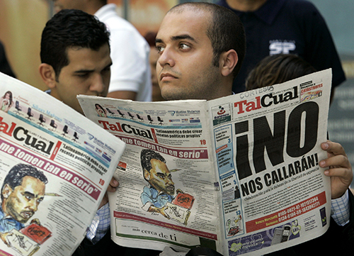 Personas leen ejemplares de Tal Cual en Caracas en 2007. El crítico periódico venezolano se ha visto obligado a reducir las operaciones en un intento por sobrevivir. (AP/Leslie Mazoch)