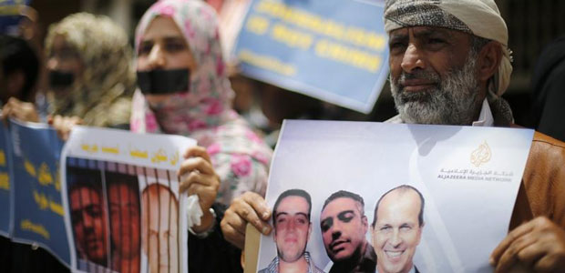 Journalists protest the imprisonment in Egypt of Al-Jazeera staffers Peter Greste, Mohamed Fahmy and Baher Mohamed outside the network's offices in Sanaa, Yemen, on June 25, 2014. (Reuters/Khaled Abdullah)