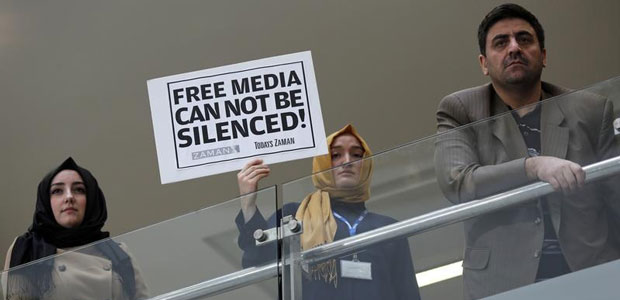صحفي يحمل لافتة في مقر صحيفة زمان اليومية في اسطنبول في 14 ديسمبر، 2014. داهمت الشرطة التركية وسائل الإعلام قريبة من  رجل الدين المسلم فتح الله غولن، المقيم بالولايات المتحدة،  بما في ذلك زمان، واعتقلت 23 شخصا. (رويترز / مراد سيزر)