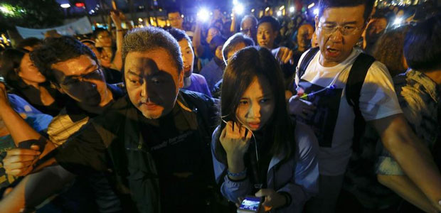Wong Wing-yin, a reporter for Hong Kong's public broadcaster, RTHK, is escorted to safety during a pro-government protest on October 25, 2014, during which three journalists were assaulted. (Reuters/Damir Sagolj)