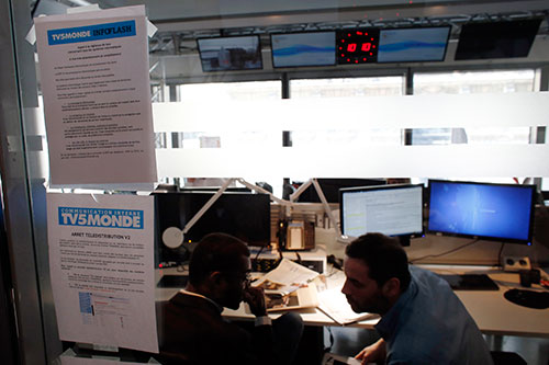 A picture taken on April 9, 2015, shows a note on the window of a newsroom at French television network TV5Monde headquarters in Paris, after TV5Monde was hacked by individuals claiming to belong to the Islamic State group. (AFP/Thomas Samson)