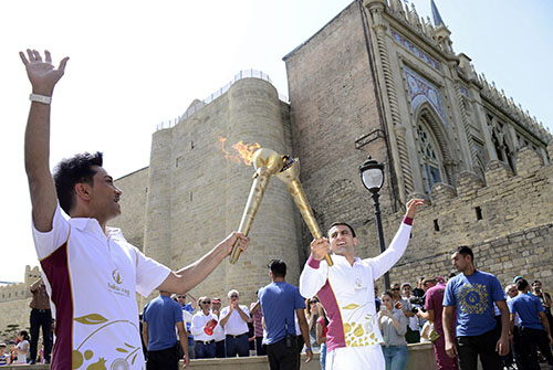Azerbaijani singer Faig Agayev, left, and wrestler Farid Mansurov take part in the Baku Games torch relay on June 9. Azerbaijan has cracked down on the press in the lead up to the first European Games. (AFP/Tofik Babayev)