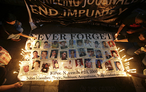 Philippine citizens light candles in memory of the 2009 Maguindanao massacre. No one has been convicted in the case, and one of the alleged masterminds died of a heart attack earlier this month. (AP Photo/Aaron Favila)