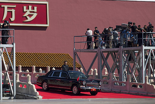 News crews film as Chinese President Xi Jinping arrives for a military parade in Beijing. In an apparent change of tone, a media group known for its liberal stance gave the event glowing coverage. (AP/Andy Wong, Pool)