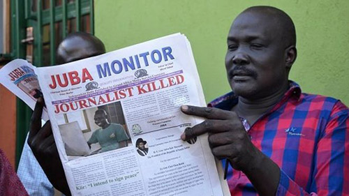 Nhial Bol reads reports about the killing of freelancer Peter Julius Moi. Many journalists in South Sudan say they are being more cautious since Moi's death. (AFP/Samir Bol)