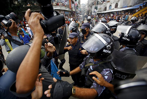 Police try to prevent journalists from covering clashes between police and protesters demonstrating against the draft of a new constitution in August 15. (Reuters/Navesh Chitrakar)