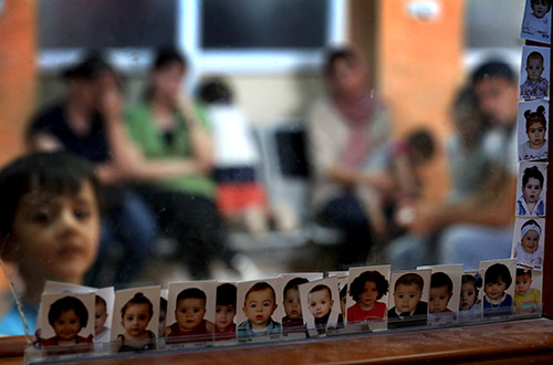 Photos of children who lost their documents while fleeing militants in Mosul are displayed at an Iraqi passport office. Many journalists fled the violence but the fate of those who remained is hard to determine. (AFP/Safin Hamed)