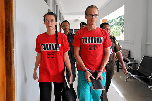 Neil Bonner and Rebecca Prosser are escorted into court in Indonesia on October 22. The British filmmakers are on trial for working without a journalist visa. (AFP/Iklil Faiz)