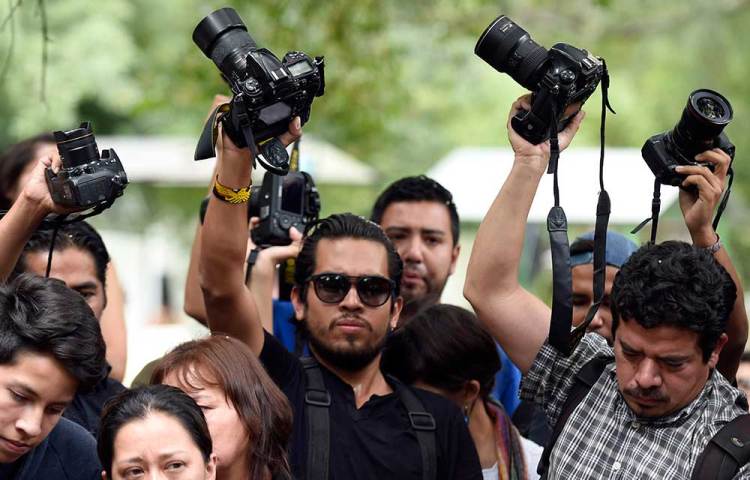 Amigos y colegas de Rubén Espinosa sostienen en alto cámaras en el funeral del asesinado fotoperiodista, en México. El puntaje de impunidad del país casi se ha duplicado desde 2008. (AFP/Alfredo Estrella)