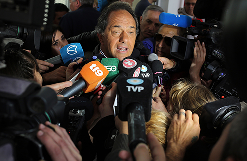 Presidential candidate Daniel Scioli is surrounded by press on election day. A pro-government TV station erroneously declared him the winner despite the vote going to a runoff in late November. (AP/Enric Marti)