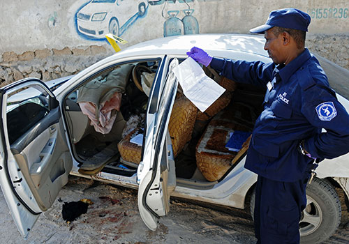 Un agent de sécurité enquête sur l'assassinat de la journaliste somalienne Hindia Haji Mohamed, qui a été tuée dans un attentat à la voiture piégée en décembre. (AFP/Mohamed Abdiwahab)