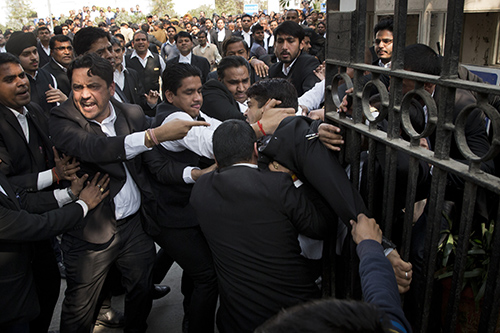 Lawyers scuffle outside a Delhi court on Wednesday. Several journalists say they were beaten by lawyers at the court in the past week. (AP/Tsering Topgyal)