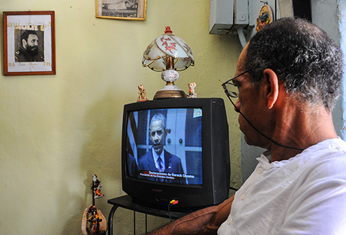 Un ciudadano cubano mira a Barack Obama dando un discurso sobre el restablecimiento de relaciones diplomáticas con Cuba. El presidente visitará Cuba la semana próxima.(AFP/Yamil Lage)
