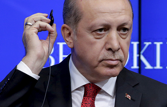 Turkish President Recip Tayyip Erdoğan removes his earpiece after speaking at the Brookings Institution, in Washington, March 31, 2016 (Joshua Roberts/Reuters).
