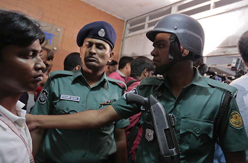 Police try to control a crowd that gathered outside the Dhaka apartment where gay rights journalist Xulhaz Mannan was stabbed. (AP/A.M.Ahad)