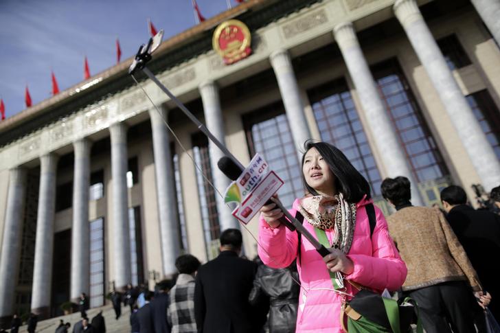 A network journalist covers delegates arriving at the National People's Congress in Beijing in March 2015. An informal survey on women journalists in China elicited enlightening responses. (Reuters/Jason Lee)