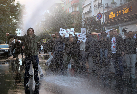 Police use water cannons to disperse protesters in front of the Istanbul headquarters of the Koza İpek media group after a court ordered it put into trusteeship, October 28, 2015. A columnist for Bugün, one of the group's former holdings, was released on June 10, 2016, after seven months' pre-trial detention. (Mehmet Ali Poyraz/Cihan News Agency/AP)