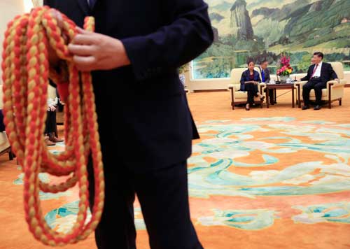 A Chinese security officer holds the media rope as U.S. National Security Adviser Susan Rice, background left, and Chinese President Xi Jinping, right, are seated for photographers at the Great Hall of the People in Beijing on July 25, 2016. Xi's increasing intolerance of negative coverage has approached a kind of lèse-majesté. (AP/How Hwee Young)