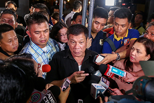 Philippine President Rodrigo Duterte, center, speaks with journalists in June. The new leader has given mixed messages on press freedom. (AFP/Manman Dejeto)