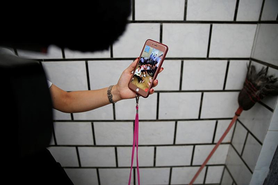 A woman shows footage on her mobile phone she says shows residents of Wukan, in China's Guangdong province, detained by police, September 14, 2016. (Reuters/Damir Salgoj)