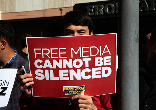 In this October 28, 2015, file photo, a demonstrator holds a sign reading "Free media cannot be silenced" at a protest in Istanbul. (AP/Lefteris Pitarakis)