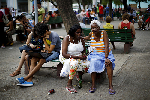 Cubanos utilizan un punto de acceso Wi-Fi en una plaza de La Habana. El acceso a la Internet cuesta 2 dólares la hora. (Reuters/Iván Alvarado)