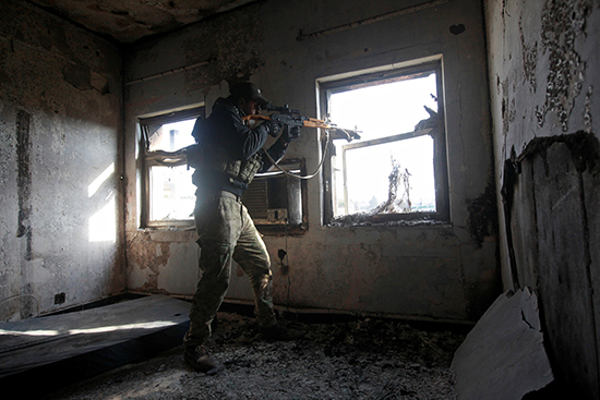 A sniper of the Iraqi rapid response team fires from the window of a hospital in eastern Mosul damaged by fighting with members of the Islamic State group, January 8, 2017. (Reuters/Alaa Al-Marjani)
