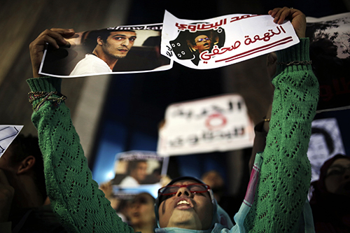 Posters calling for the release of photojournalists Mohammad al-Batawi, right, and Shawkan, are held up in Cairo. A U.N. working group says that Shawkan's detention is arbitrary. (AP/Amr Nabil)
