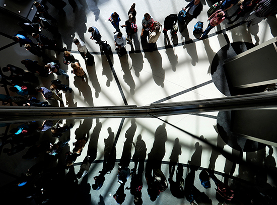 Travelers are reflected in glass as they line up for security at the international airport in Atlanta, Georgia, March 10, 2016. (AP/David Goldman)