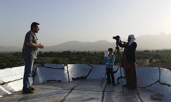 Afghan journalist Zabihullah Tamanna, left, broadcasts from outside Kabul in May 2015. Tamanna and U.S. reporter David Gilkey were killed in 2016 while working for NPR. (AFP/Parwiz Sabawoon)