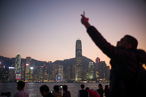 Tourists photograph Hong Kong's skyline. A group of new websites has emerged in the city to counter the restrictive climate for the press. (Anthony Wallace/AFP)